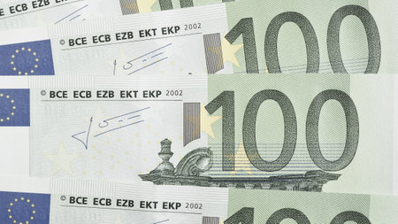 Notes of 100 euros close-up. Light background about economy and finance of European Union. News pale wallpaper about euro. Eurozone currency and ECB. Banking in Europe. Macroの写真素材