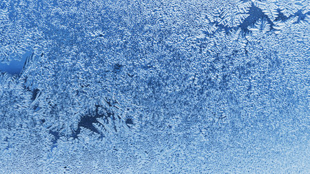 Frosting on a window glass in winter. weather forecast. Blue tinted wallpaper. Abstract nature background. christmas themeの写真素材