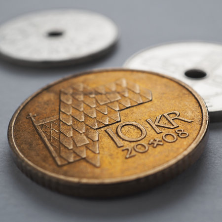 Norwegian coins lie on gray surface. 10 Norges kroner coin close up. National currency of Norway. Money square illustration about economy or finance. banking and credit. Wages and taxes. Macroの写真素材