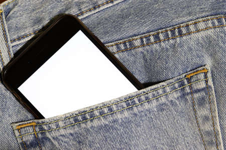 Mock up white screen phone peeping out of the pocket of light blue jeans. Template for design. Denim...