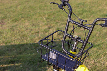 Handlebar with a basket up close. Advertising template. The concept of recreation, sports. Active lifestyle. Delivery by bike. Grass on the background blurred background. Summer nature. Empty space for text.の写真素材