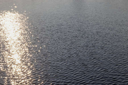 Water surface with reflection of light rays. The concept of tourism, tranquility and relaxation. Copy space for text.の写真素材