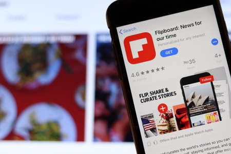 Los Angeles, California, USA - 21 November 2019: Flipboard logo on phone screen with icon on laptop on blurry background, Illustrative Editorial.のeditorial素材