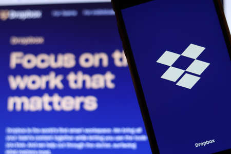 Los Angeles, California, USA - 21 November 2019: Dropbox logo on phone screen with icon on laptop on blurry background, Illustrative Editorial.のeditorial素材