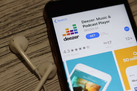 Los Angeles, California, USA - 27 November 2019: Deezer music and podcast player App Store page close up with earphones, Illustrative Editorial.のeditorial素材