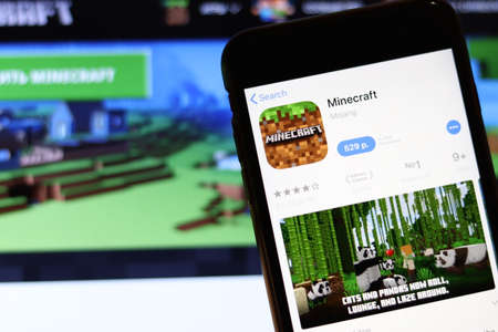 Los Angeles, California, USA - 28 November 2019: Minecraft app icon on mobile phone screen with logo on laptop on blurry background, Illustrative Editorial.のeditorial素材