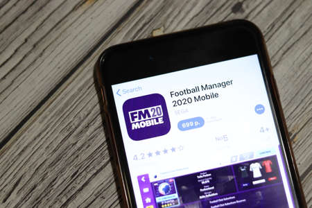 Los Angeles, California, USA - 28 November 2019: Football Manager 2020 Mobile app icon on mobile phone screen top view, Illustrative Editorial.のeditorial素材