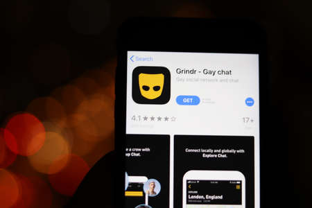 Los Angeles, California, USA - 28 November 2019: Grindr app logo on mobile phone screen with blurry background, Illustrative Editorial.のeditorial素材