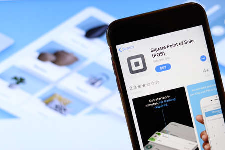 Phone with Square Point of Sale POS icon on screen close up with blur website on laptop. Los Angeles, California, USA - 30 November 2019, Illustrative Editorial.のeditorial素材