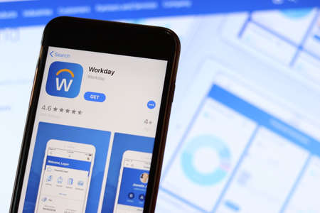 Phone with Workday icon on screen close up with blur website on laptop. Los Angeles, California, USA - 30 November 2019, Illustrative Editorial.のeditorial素材