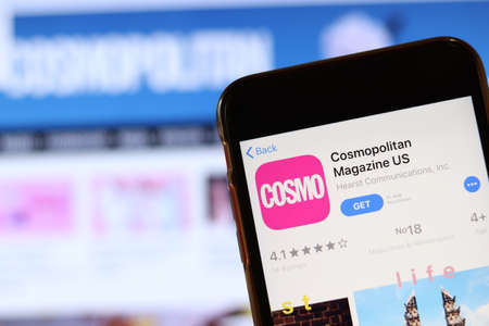 Phone with Cosmopolitan Magazine icon on screen close up with blur website on laptop. Los Angeles, California, USA - 30 November 2019, Illustrative Editorial.のeditorial素材
