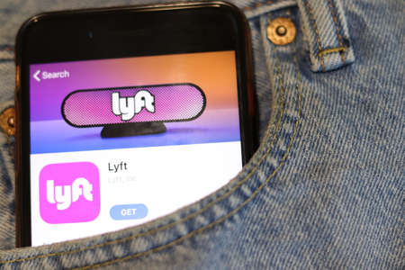 Phone with Lyft icon on screen in blue jeans pocket close-up. Los Angeles, California, USA - 30 November 2019, Illustrative Editorial.のeditorial素材