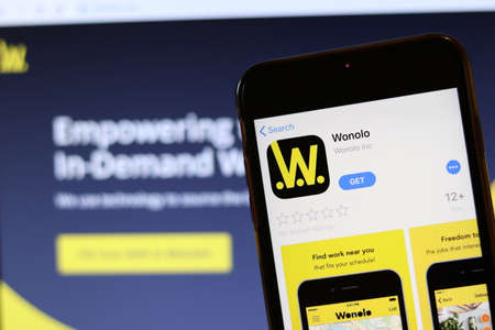 Phone with Wonolo icon on screen close up with blur website on laptop. Los Angeles, California, USA - 30 November 2019, Illustrative Editorial.のeditorial素材