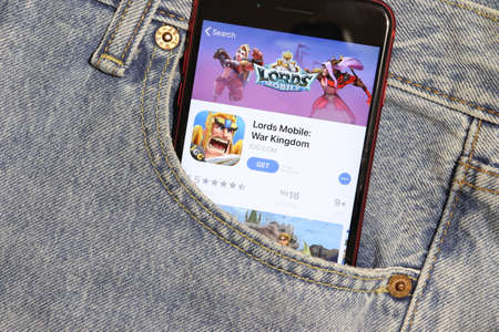 Los Angeles, California, USA - 5 December 2019: Lords Mobile War Kingdom app icon on phone screen in blue jeans pocket. App Store logo on Iphone with light denim Background, Illustrative Editorial.のeditorial素材
