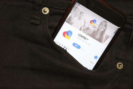 Saint-Petersburg, Russia - 6 December 2019: Mobile phone screen with LOVOO icon in pocket close-up, Illustrative Editorial.のeditorial素材