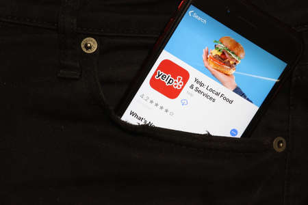 Saint-Petersburg, Russia - 6 December 2019: Mobile phone screen with YELP app icon in pocket close-up, Illustrative Editorial.のeditorial素材