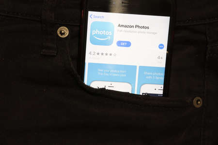 Saint-Petersburg, Russia - 6 December 2019: Mobile phone screen with Amazon Photos icon in pocket close-up, Illustrative Editorial.のeditorial素材