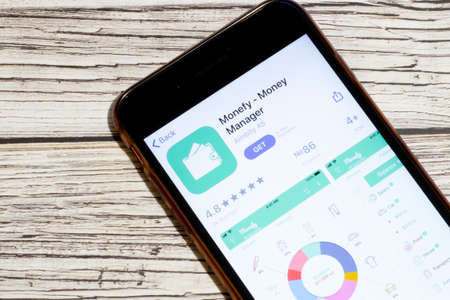 Los Angeles, California, USA - 25 January 2020: Logo of Monefy Money Manager mobile app on phone screen close up top view on wooden table, Illustrative Editorial.のeditorial素材
