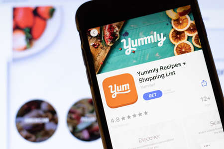 Los Angeles, California, USA - 12 February 2020: Mobile phone with Yummly icon on screen close up with website on laptop, Illustrative Editorial.のeditorial素材