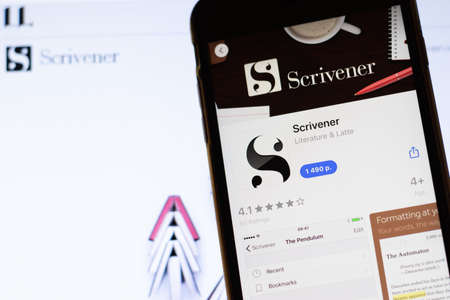 Los Angeles, California, USA - 12 February 2020: Mobile phone with Scrivener icon on screen close up with website on laptop. Blurred background with Scrivener.com site, Illustrative Editorial.のeditorial素材