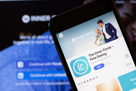 Los Angeles, California, USA - 24 March 2020: The Inner Circle app logo on phone screen close up with website on background with icon, Illustrative Editorial.のeditorial素材