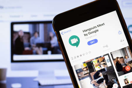 Los Angeles, California, USA - 24 March 2020: Hangouts Meet by Google app logo on phone screen close up with website on background with icon, Illustrative Editorial.のeditorial素材