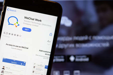Los Angeles, California, USA - 24 March 2020: WeChat Work app logo on phone screen close up with website on background with icon, Illustrative Editorial.のeditorial素材