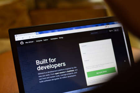 New York, USA - 9 April 2020: GitHub website on laptop screen close up. Man using service on display, blurry background, Illustrative Editorial.のeditorial素材