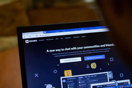 New York, USA - 9 April 2020: Discrord app website on laptop screen close up. Man using service on display, blurry background, Illustrative Editorial.のeditorial素材