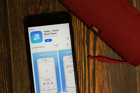 Los Angeles, California, USA - 16 April 2020: Tubizy logo on screen top view close-up. App store icon visible on phone display, Illustrative Editorial.のeditorial素材