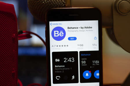 Los Angeles, California, USA - 16 April 2020: Behance by Adobe logo on screen close up. App store icon visible on phone display, Illustrative Editorial.のeditorial素材