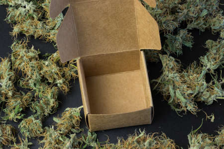 Empty open brown box on cannabis background top view.の写真素材