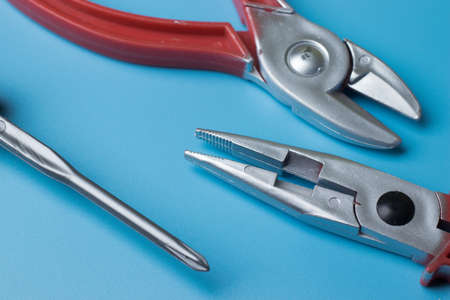 Home repair tools flat lay on blue background above view.