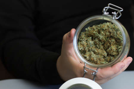 Glass jar full of cannabis buds ready to smoke. Marijuana smoking industry business