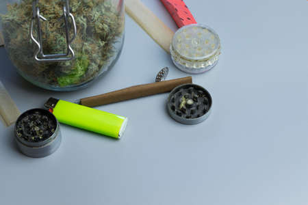 Grinder, lighter and smoking paper for cannabis medical use. Healthcare and THC. Marijuana treatment of anxiety. Copy space near weed jar.の写真素材