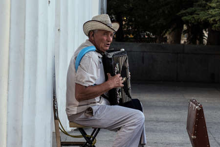 Sevastopol, Crimea - 29 September 2020: Old man playing on accordion on street, Illustrative Editorial.のeditorial素材