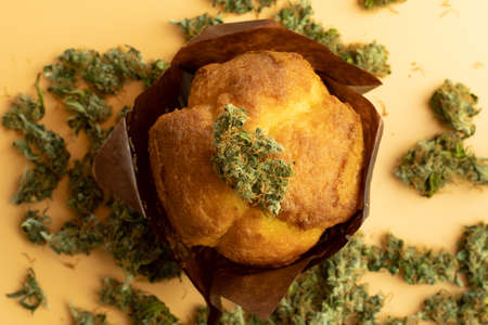 Marijuana bud on muffin with THC. Cannabis product concept. Weed background top view.