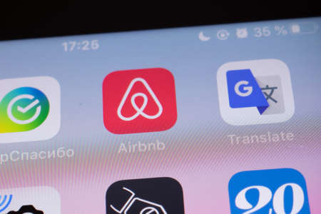 New York, USA - 26 April 2021: Airbnb app logo on phone screen close-up top view, Illustrative Editorialのeditorial素材