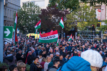 Budapest, Hungary - 1 November 2021: Crowd of people at a rally with Hungarian flags. Meeting or demonstration in the street. Political activity in Hungary, Illustrative Editorial.のeditorial素材