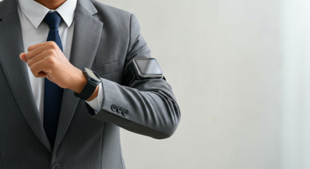 Man in a suit and tie is wearing a wristwatch and a smart watch. He is wearing a smart watch on his armの素材