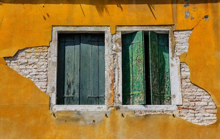 Old Green wooden window on the yellow facadeの写真素材