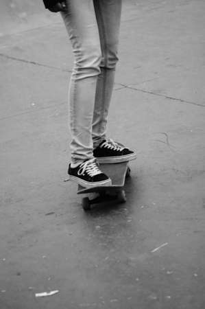 Legs of a girl skating with a skateboard in black and whiteの写真素材