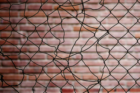 Broken fence with an out of focus bricks backgroundの写真素材