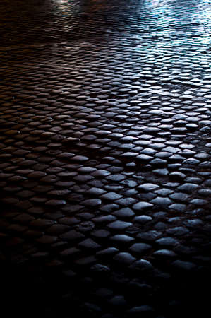 Small cobblestone in the night with car lights in Romeの写真素材