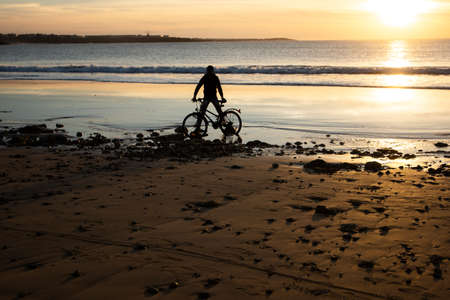 Orange sunset on a nice blue beach in the coast of Moroccoの写真素材
