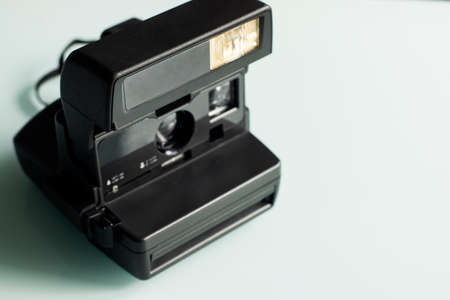 Retro old fashioned instant camera on a white glass backgroundの写真素材