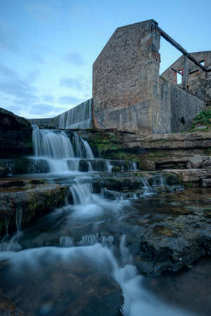 River flow next to an old ruined mill in the early morningの写真素材