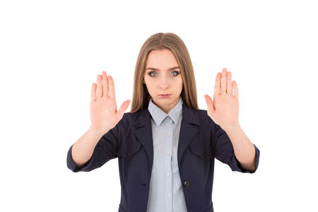 Stop it! Confident young businesswoman in suit stretching out hands and showing her palms while standing against white backgroundの写真素材