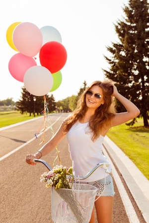 happy girl riding on a bicycle with flowersの写真素材