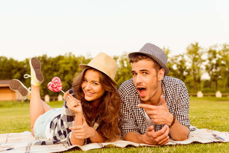 lovers lying on the grass with lollipopの写真素材